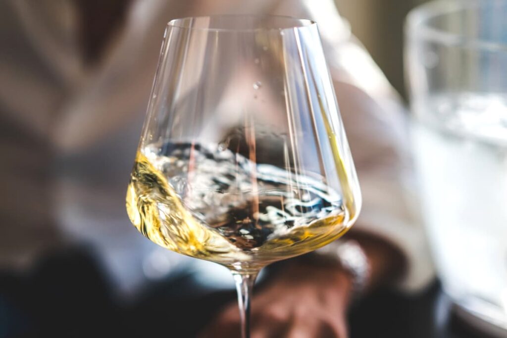 A glass of dry white wine being swirled. 