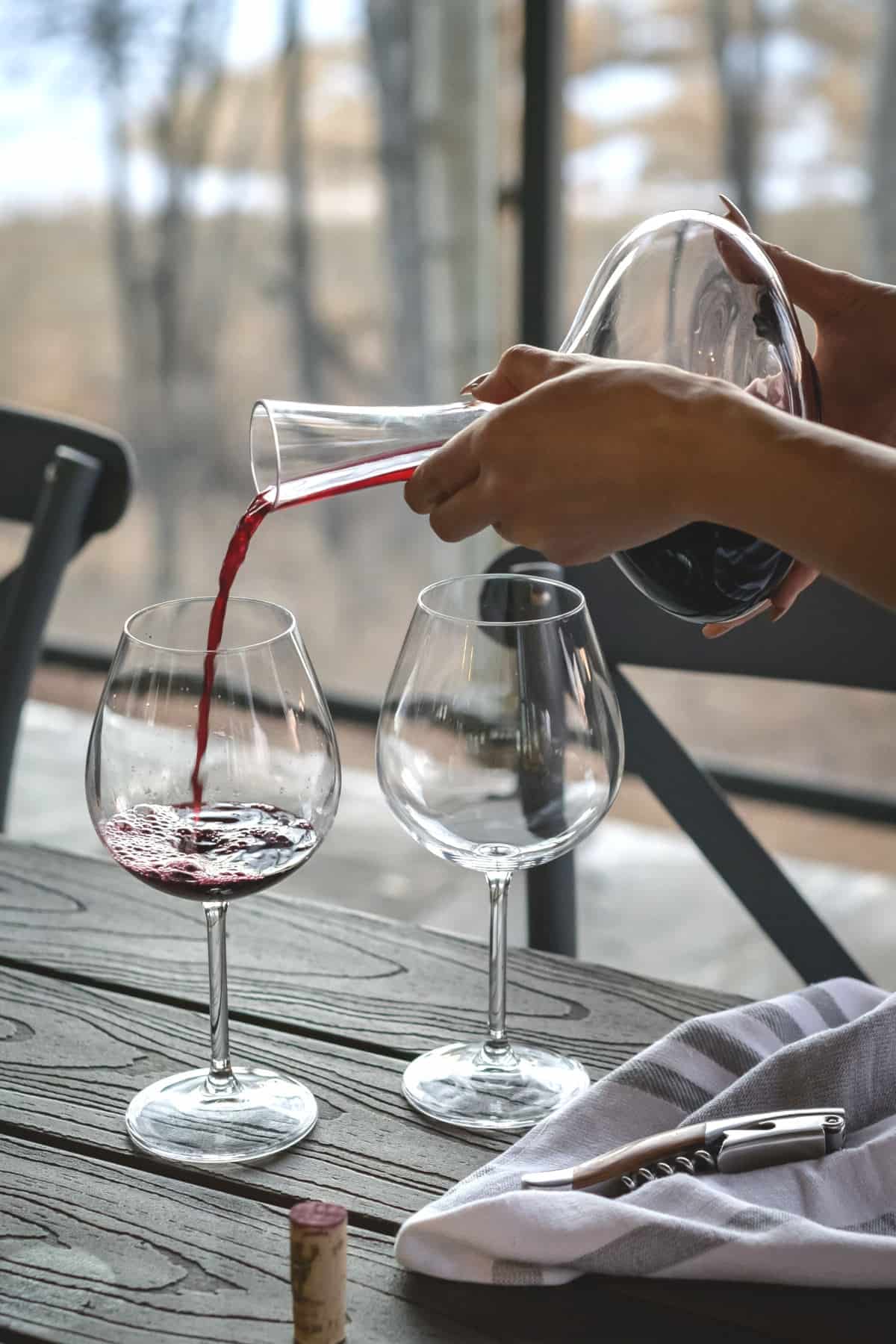Red wine being poured from a decanter. 